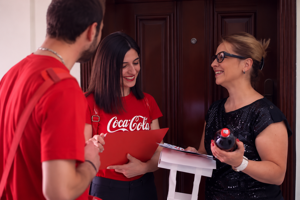 Coca-Cola home sampling campaign by Aurora Baréalisse, featuring branded ambassadors delivering Coca-Cola bottles to families in Armenia.